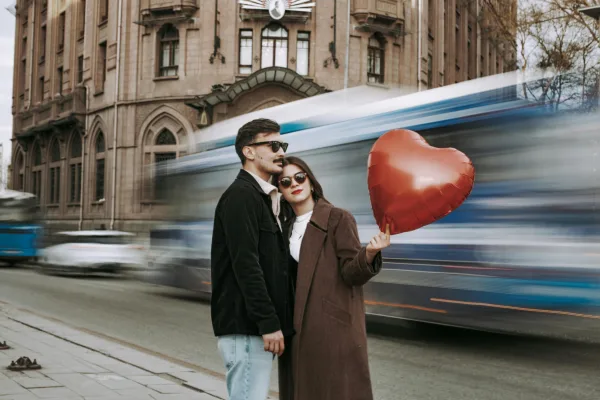 Couple élégant avec ballon cœur rouge en pleine ville