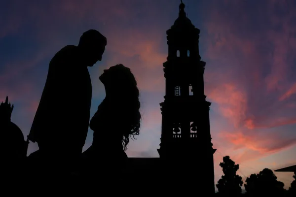 Silhouette romantique d’un couple au crépuscule devant une tour