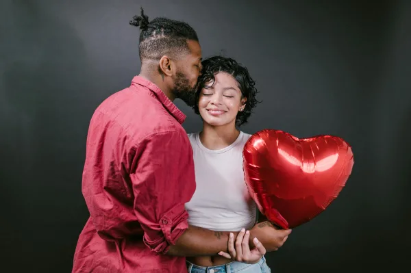 Couple romantique avec ballon cœur rouge et moment de tendresse