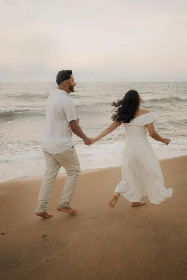Couple romantique marchant main dans la main sur la plage