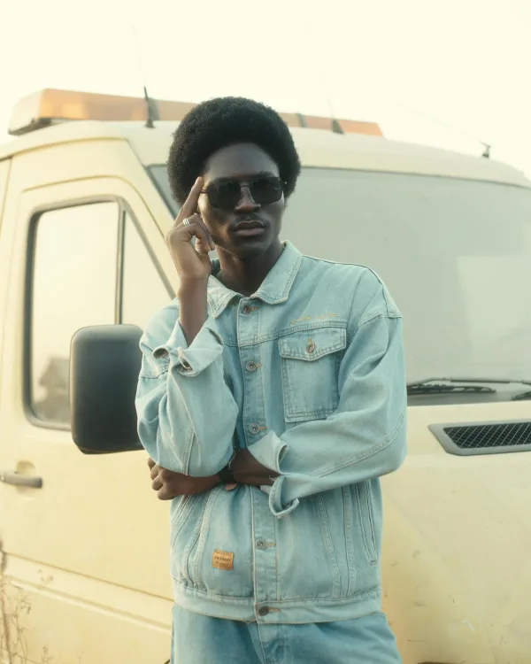 Portrait d’homme élégant en veste en jean et lunettes noires