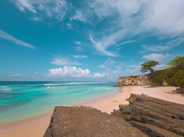 Plage paradisiaque aux eaux turquoise et falaises rocheuses