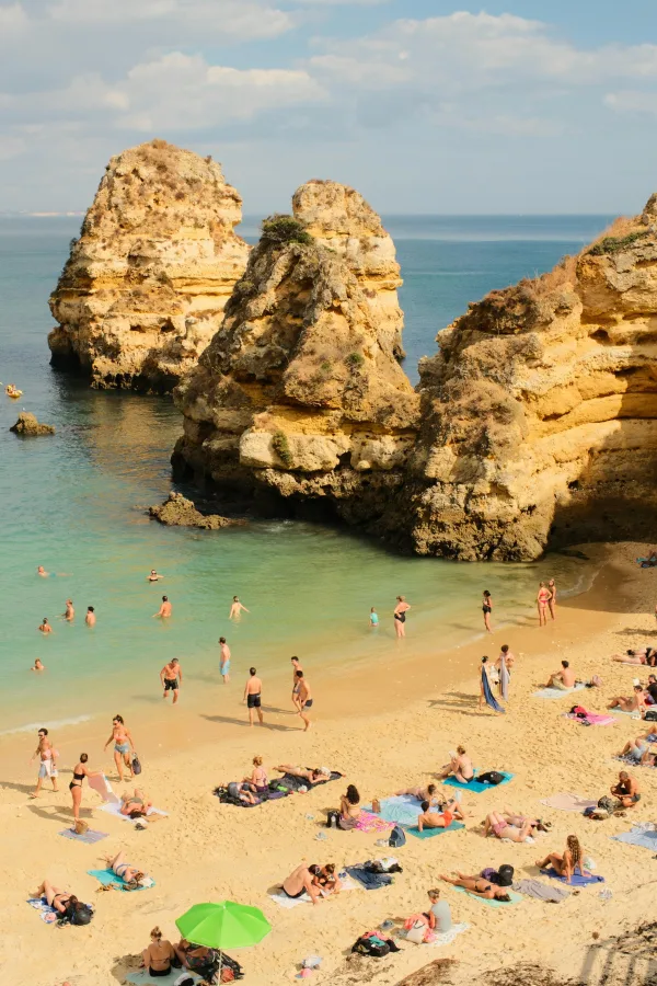 Plage tropicale entre falaises dorées et eau turquoise