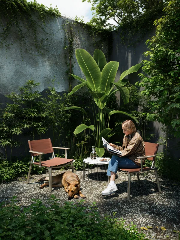Femme lisant dans un jardin tropical avec son chien