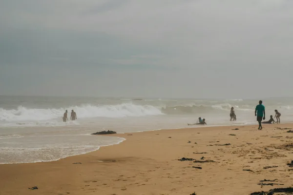 Plage sauvage avec vagues et promeneurs au bord de mer