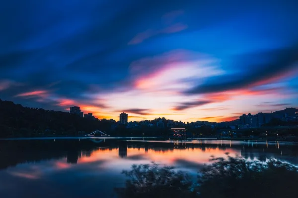 Coucher de soleil urbain reflété sur un lac au crépuscule