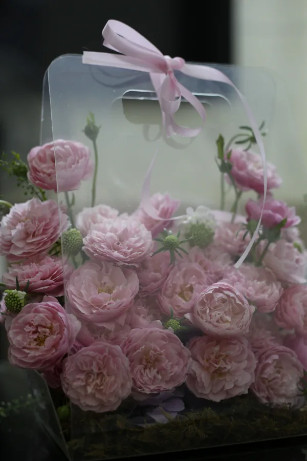 Bouquet de roses roses élégantes dans une boîte cadeau transparente