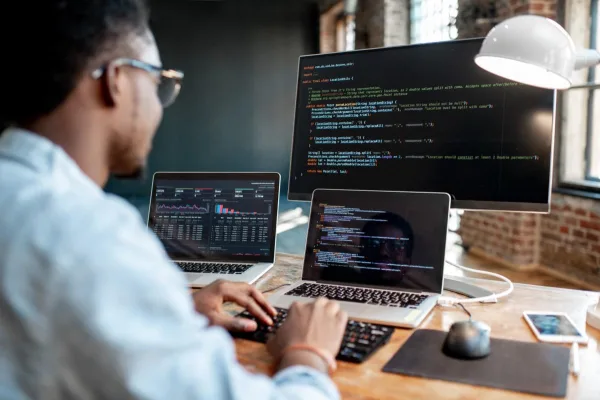 Développeur web travaillant sur plusieurs écrans de code