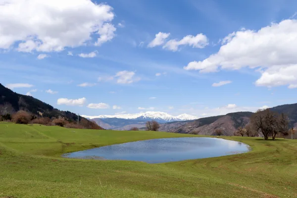 Lac paisible dans une vallée de montagne sous un ciel bleu