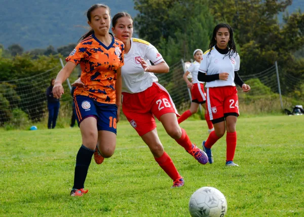 Jeunes joueuses disputant un match de football sur terrain extérieur