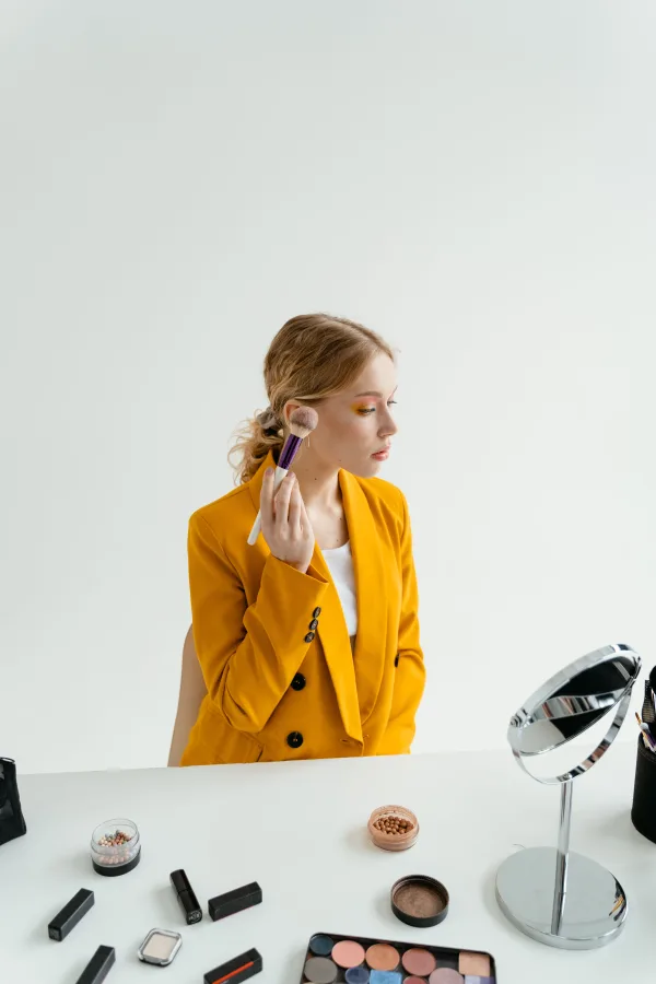 Jeune femme appliquant son maquillage devant un miroir dans un studio moderne