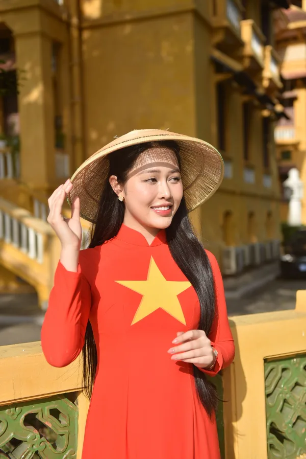 Femme portant un áo dài rouge et un chapeau conique traditionnel vietnamien