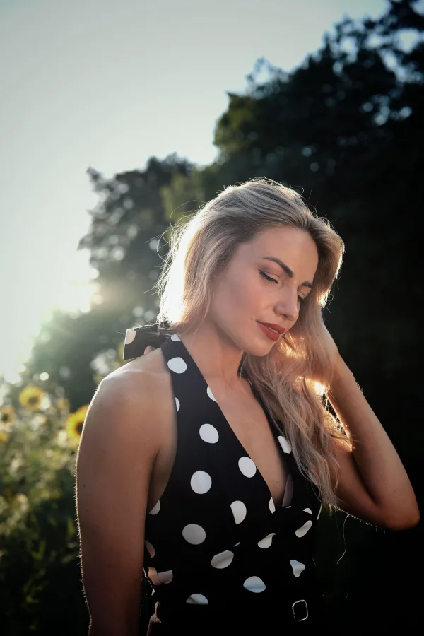 Portrait d'une femme blonde en robe à pois au coucher du soleil
