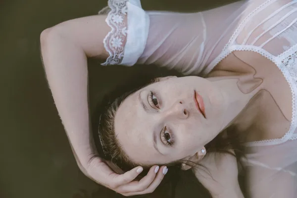 Portrait artistique d’une femme allongée avec lumière douce et expression naturelle