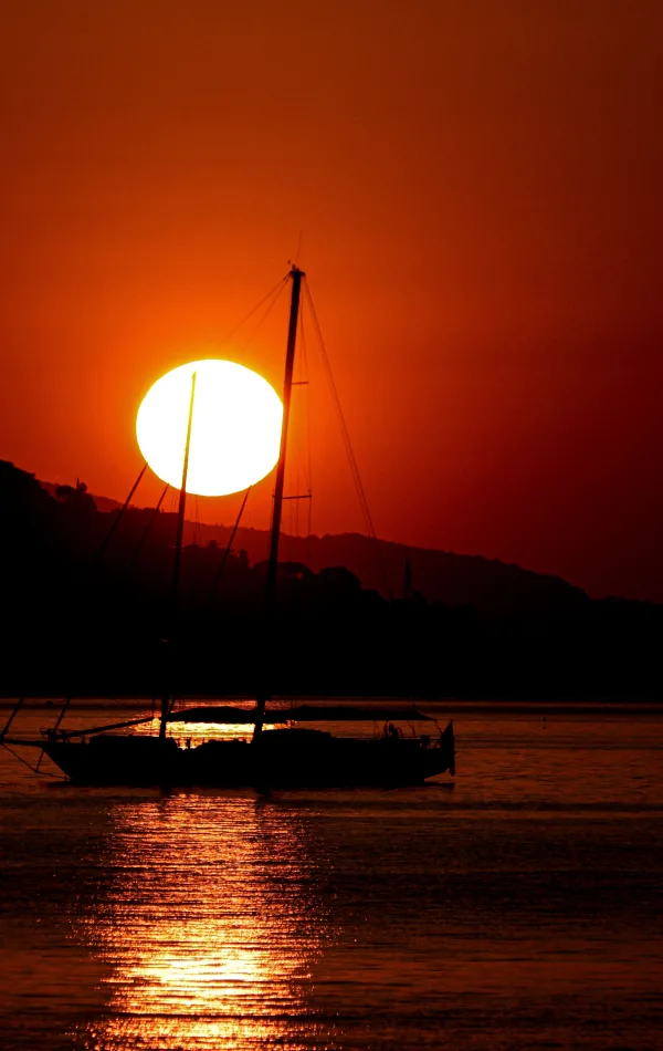Voilier au coucher du soleil sur une mer calme