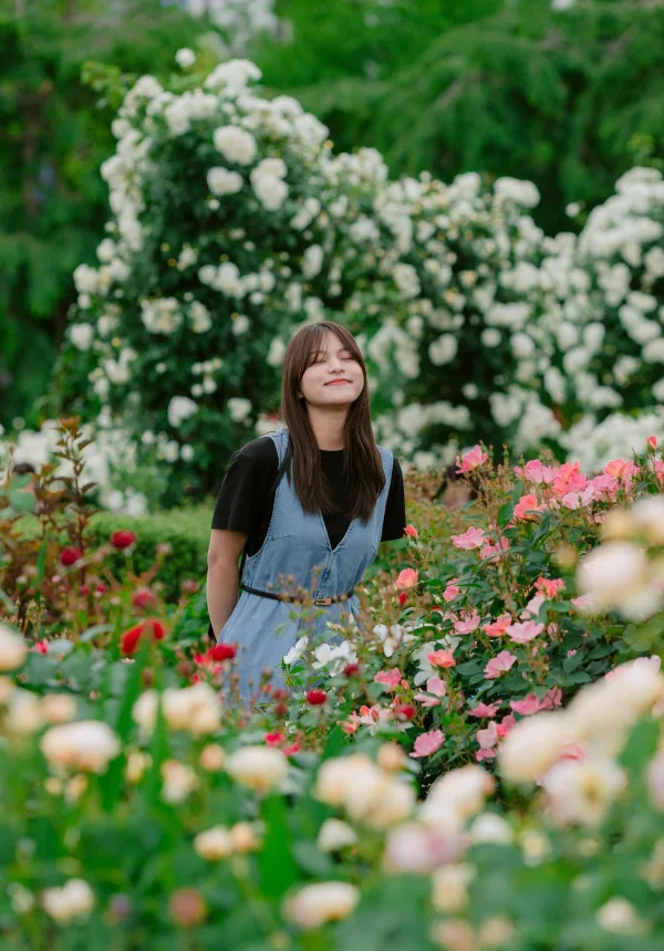 Jeune femme dans une roseraie en fleurs – Portrait nature et bien-être