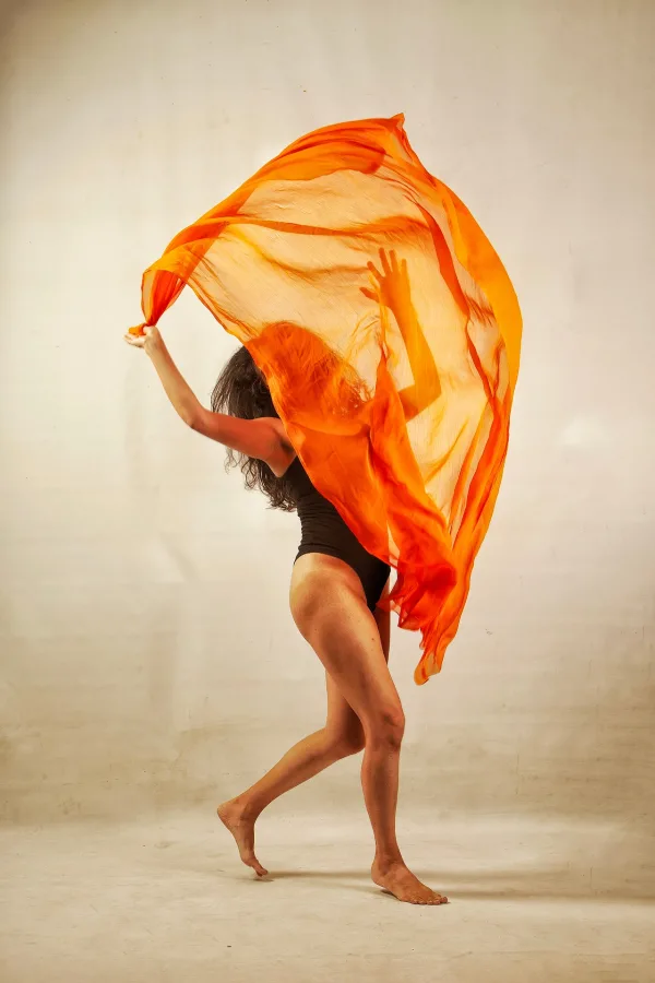 Danseuse contemporaine avec voile orange – Photo artistique de mouvement et d’expression