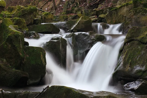 Cascade en forêt sur des rochers moussus – Paysage naturel en pose longue