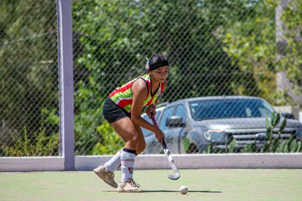 Joueuse de hockey sur gazon en pleine action sur un terrain extérieur