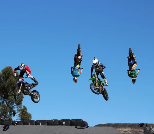 Pilotes de motocross réalisant des figures aériennes spectaculaires en plein ciel
