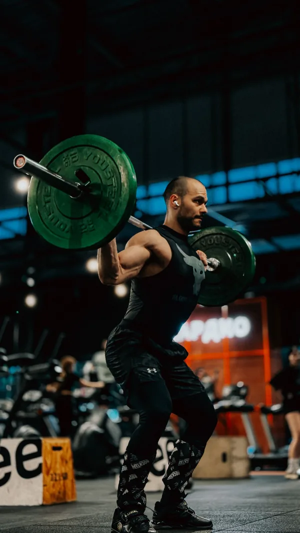 Athlète réalisant un squat avec barre olympique dans une salle de musculation