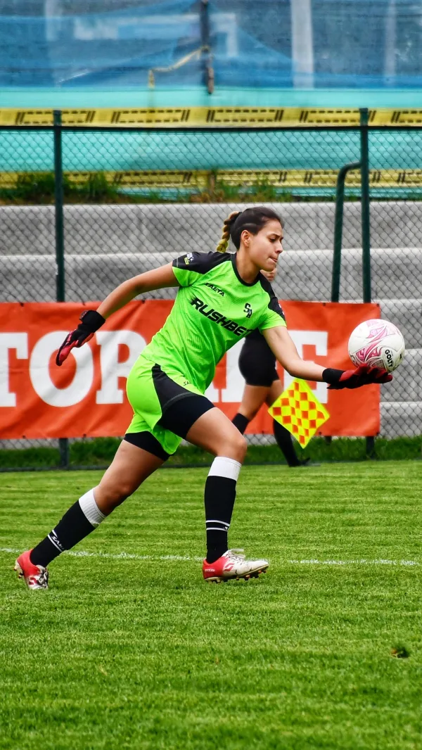 Gardienne de but de football attrapant le ballon pendant un match