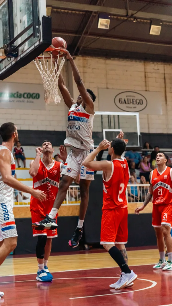 Joueur de basketball réalisant un dunk pendant un match en salle