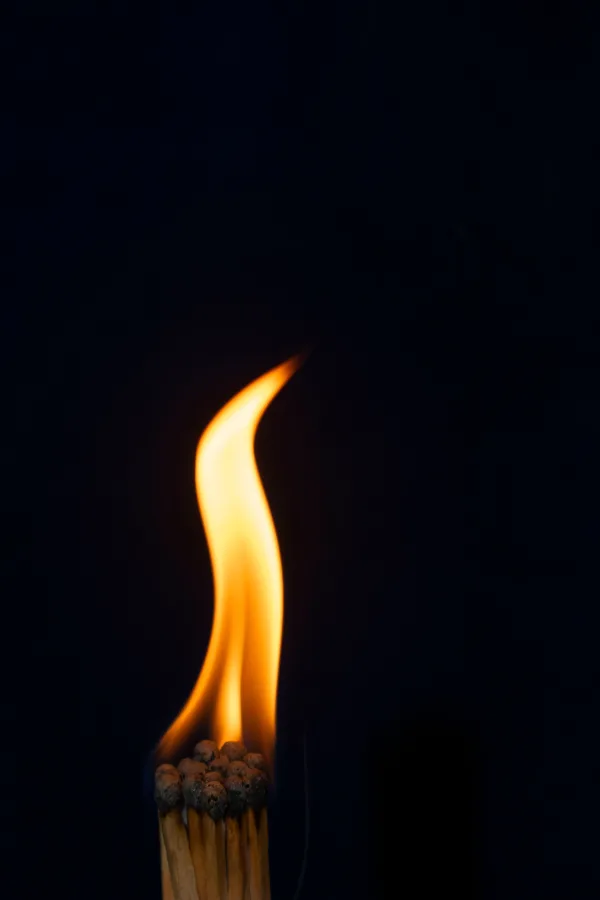 Flamme d’allumettes sur fond noir – photographie minimaliste du feu