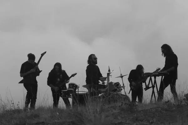 Groupe de musique en silhouette jouant en plein air en noir et blanc