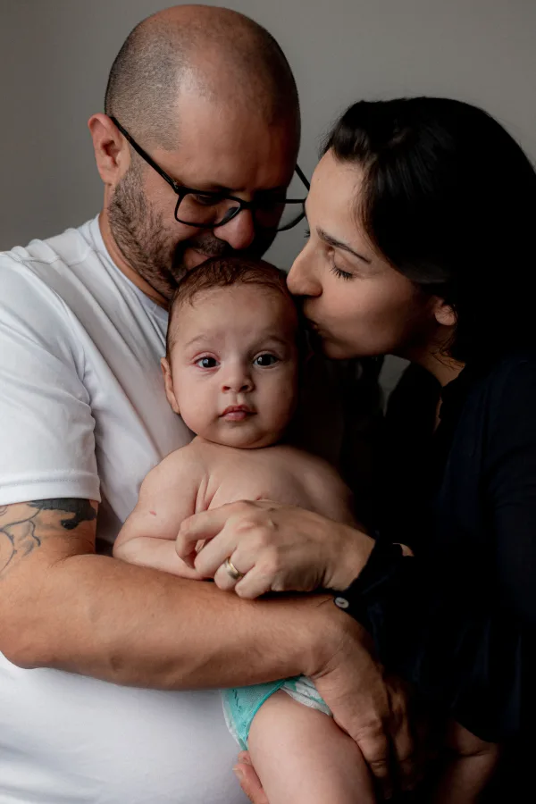 Portrait tendre de jeunes parents avec leur bébé dans les bras