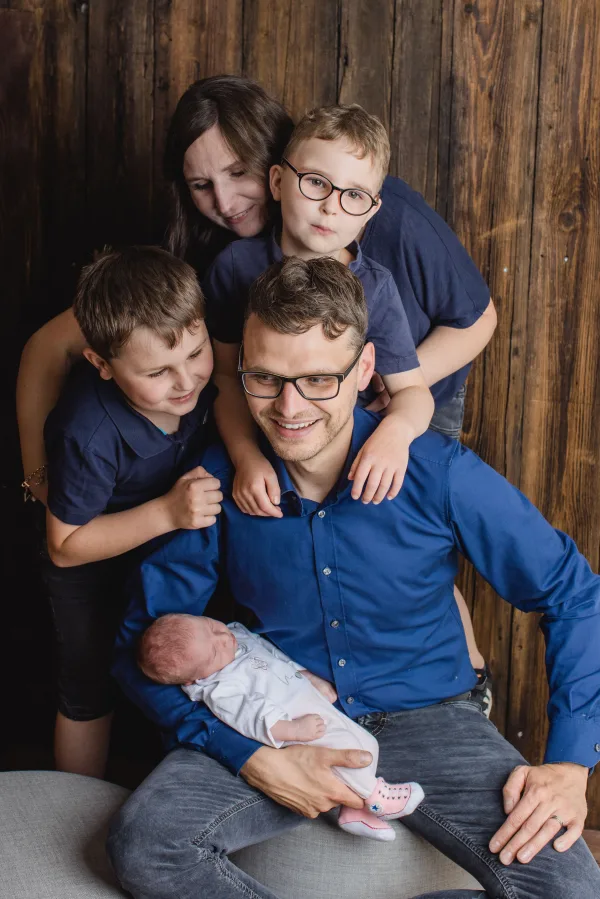 Grande famille réunie autour d’un nouveau-né dans un portrait chaleureux