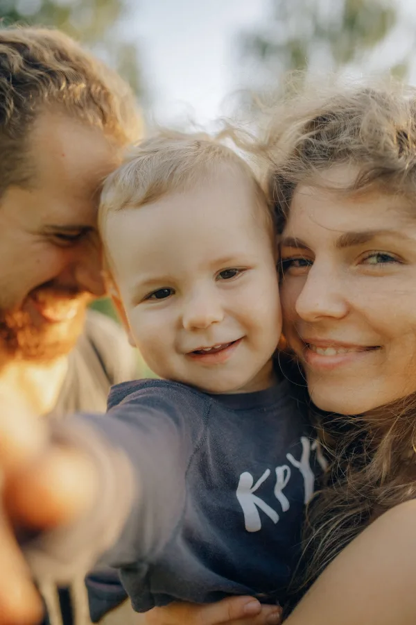 Jeune famille prenant un selfie avec leur enfant en plein air