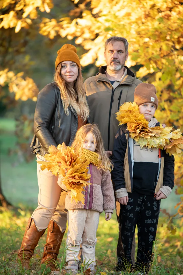 Famille en automne tenant des feuilles colorées dans un parc