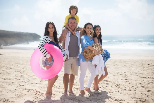 Famille heureuse en vacances sur la plage en été