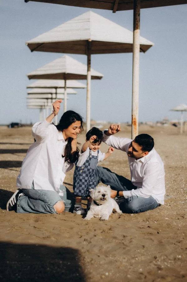 Famille avec enfant et chien sur la plage en vacances