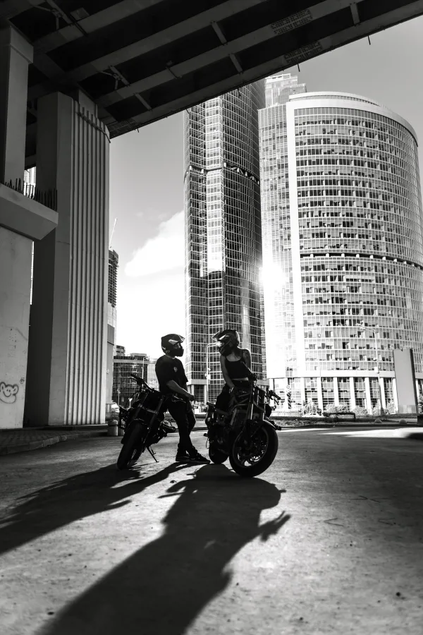 Motards urbains devant des gratte-ciel modernes en noir et blanc