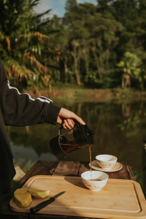 Préparation de café en plein air au bord d’un lac entouré de nature