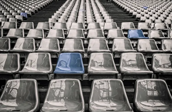 Gradins de stade vides avec sièges gris et bleus en perspective