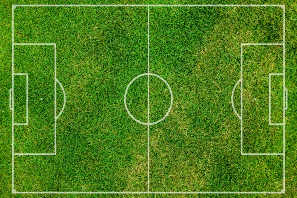 Terrain de football vu du ciel avec marquages blancs sur pelouse verte