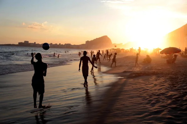 Plage animée au coucher du soleil avec familles et enfants jouant au bord de la mer
