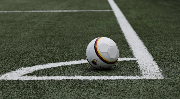 Ballon de football posé sur le point de corner d'un terrain