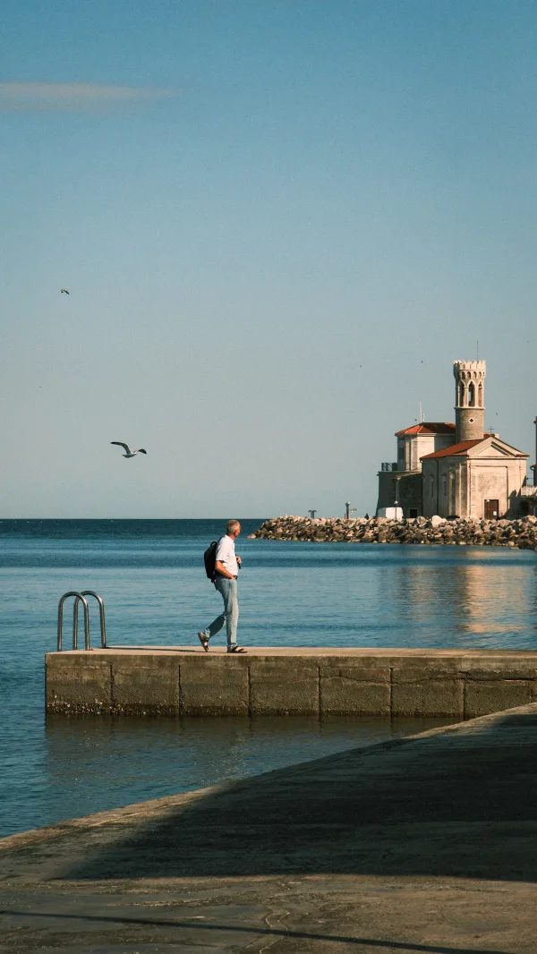 Promenade sur un quai face à la mer et à une église côtière