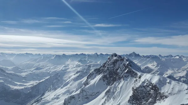 Chaîne de montagnes enneigées sous un ciel bleu panoramique