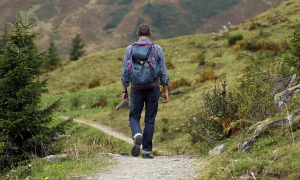 Randonneur avec sac à dos sur un sentier de montagne en pleine nature