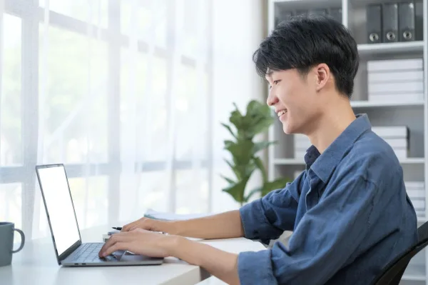 Jeune professionnel travaillant sur un ordinateur portable dans un bureau lumineux