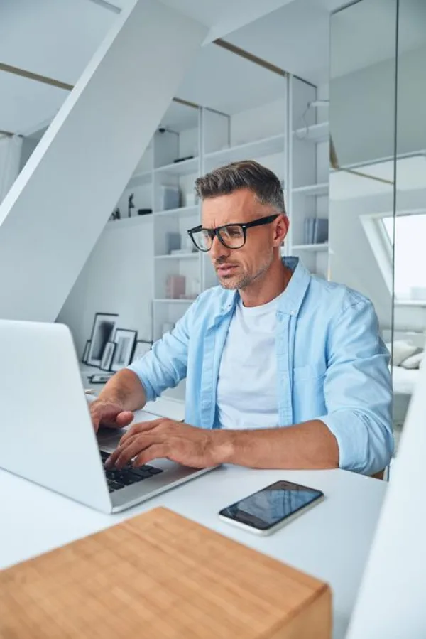 Professionnel travaillant sur ordinateur portable dans un bureau à domicile moderne