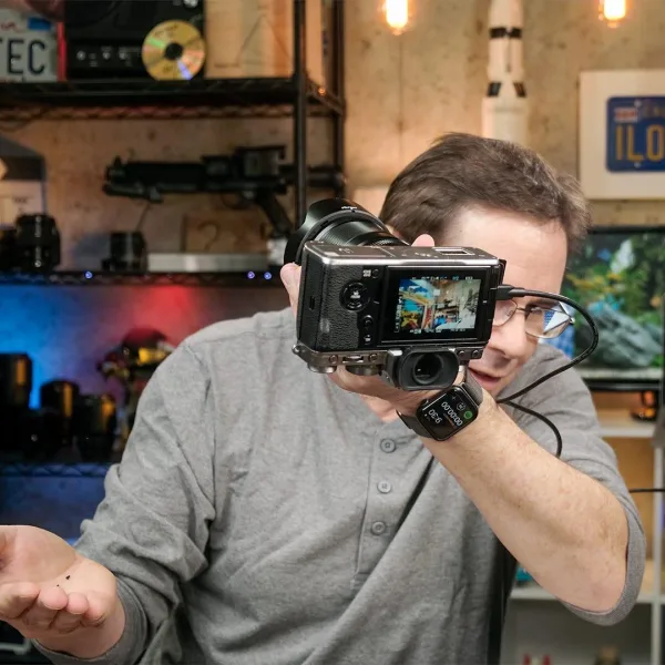 Créateur de contenu filmant avec une caméra hybride dans un studio vidéo