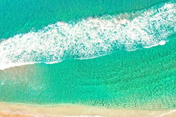 Vue aérienne d'une plage tropicale aux eaux turquoise et vagues