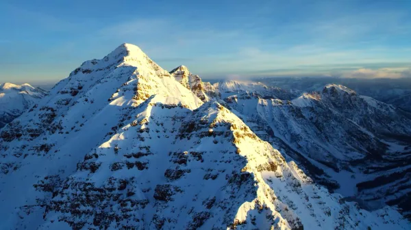 Sommet enneigé illuminé par le soleil au lever du jour