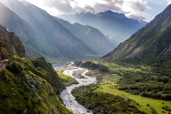 Vallée de montagne traversée par une rivière sous les rayons du soleil